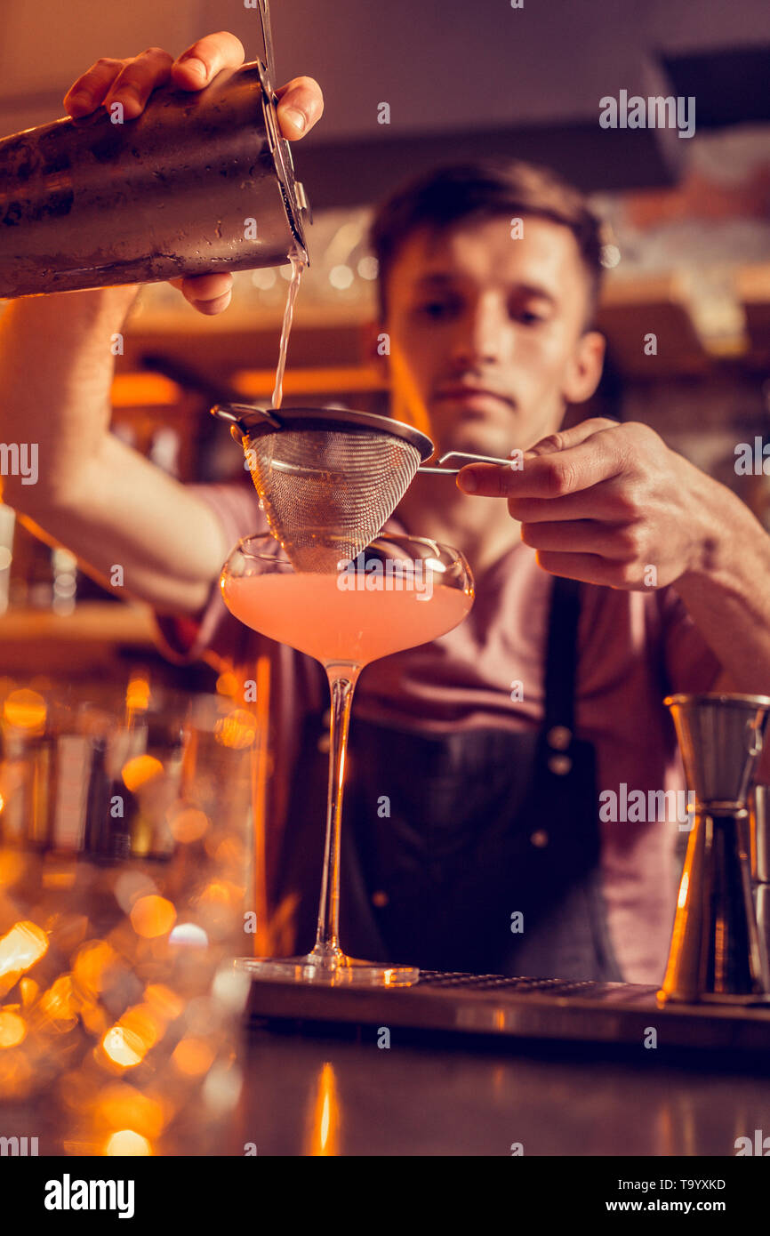 Barman using sieve while making cocktail with juice Stock Photo Alamy