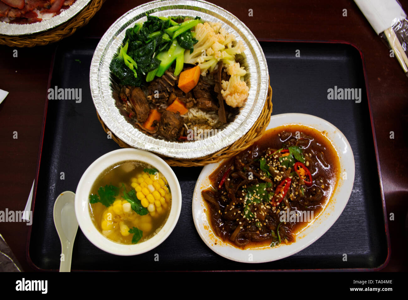 Chinese food set rice topping with boil duck sweet brown sauce with vegetable and corn clear soup and fried spicy jellyfish in local restaurant at Sha Stock Photo