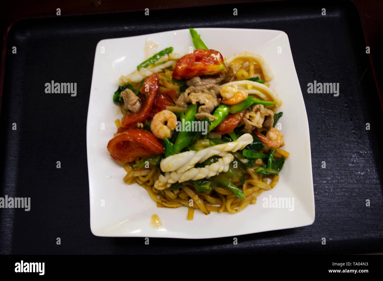 Chinese food fried egg noodle in sticky brown sauce and thick gravy with vegetable and meat seafood in local restaurant at Shantou town or Swatow city Stock Photo