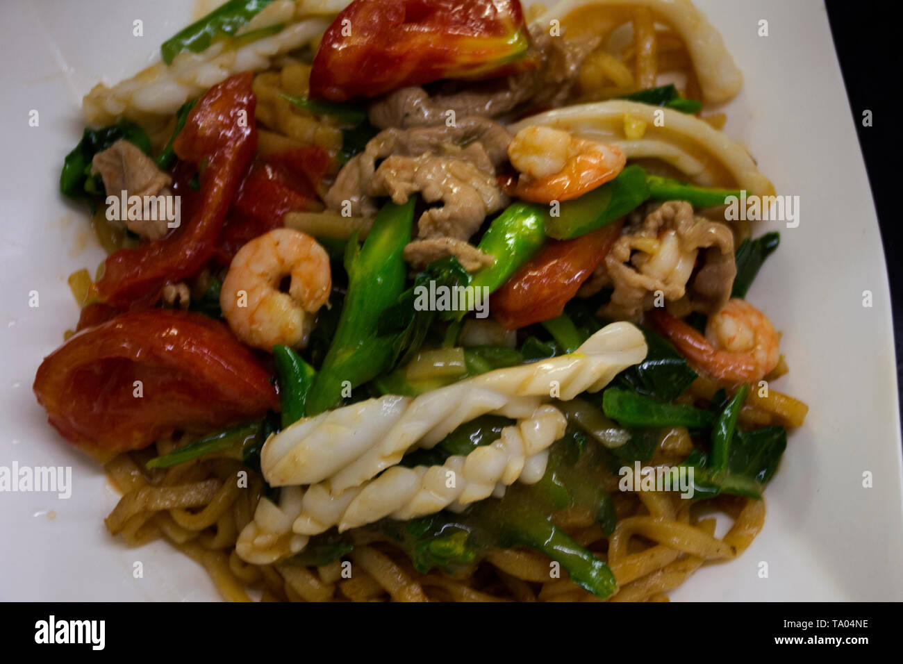 Chinese food fried egg noodle in sticky brown sauce and thick gravy with vegetable and meat seafood in local restaurant at Shantou town or Swatow city Stock Photo