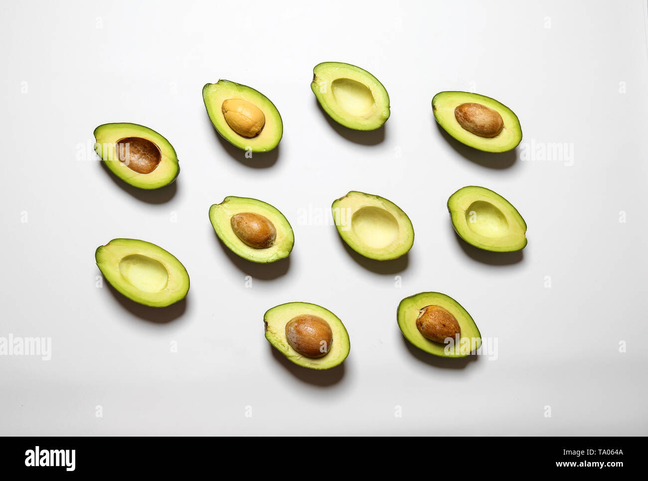 Plenty of fresh avocados on white background Stock Photo