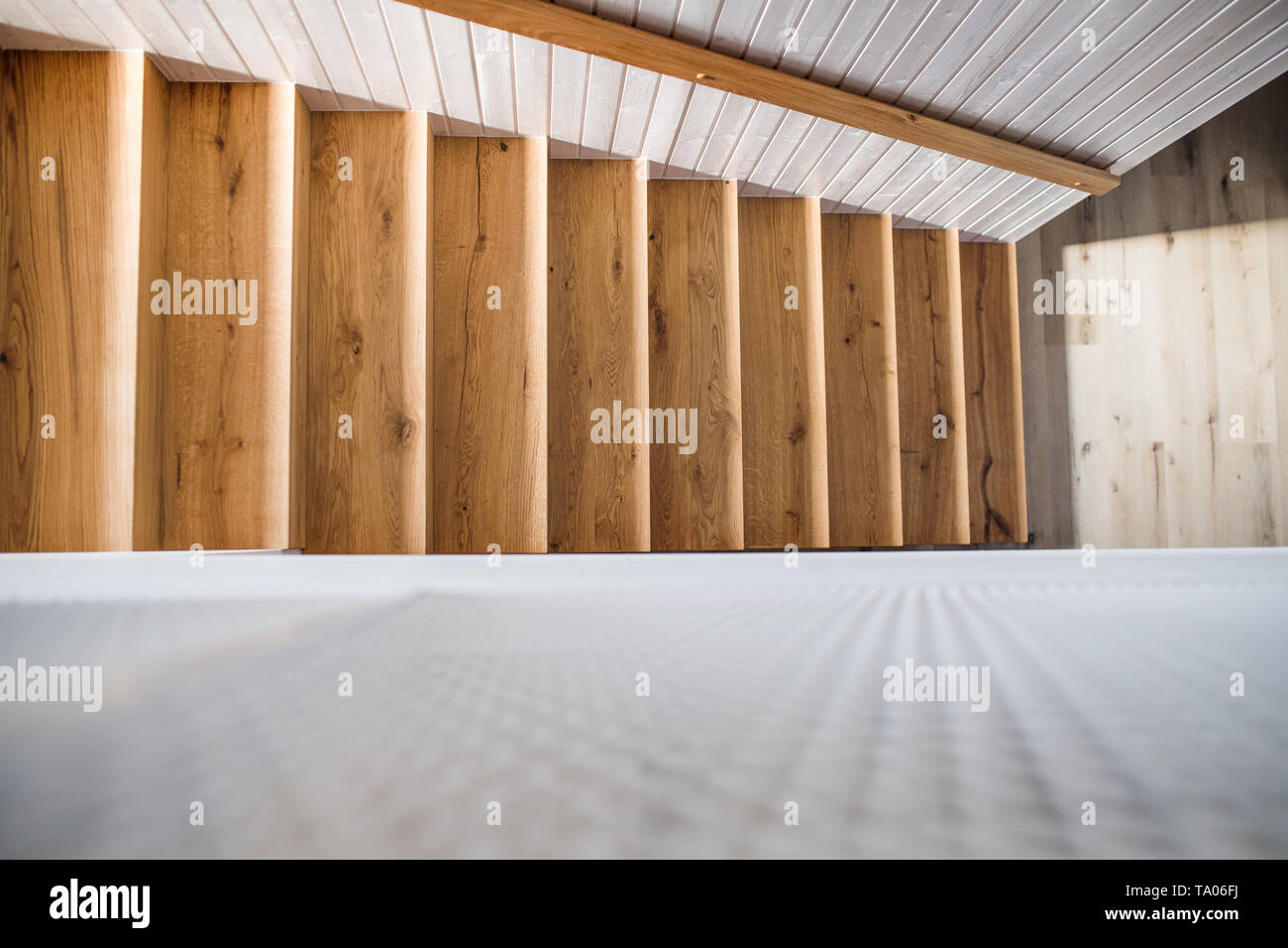 A Top Of Wooden Staircase And White Wood Board Wall In An Interior