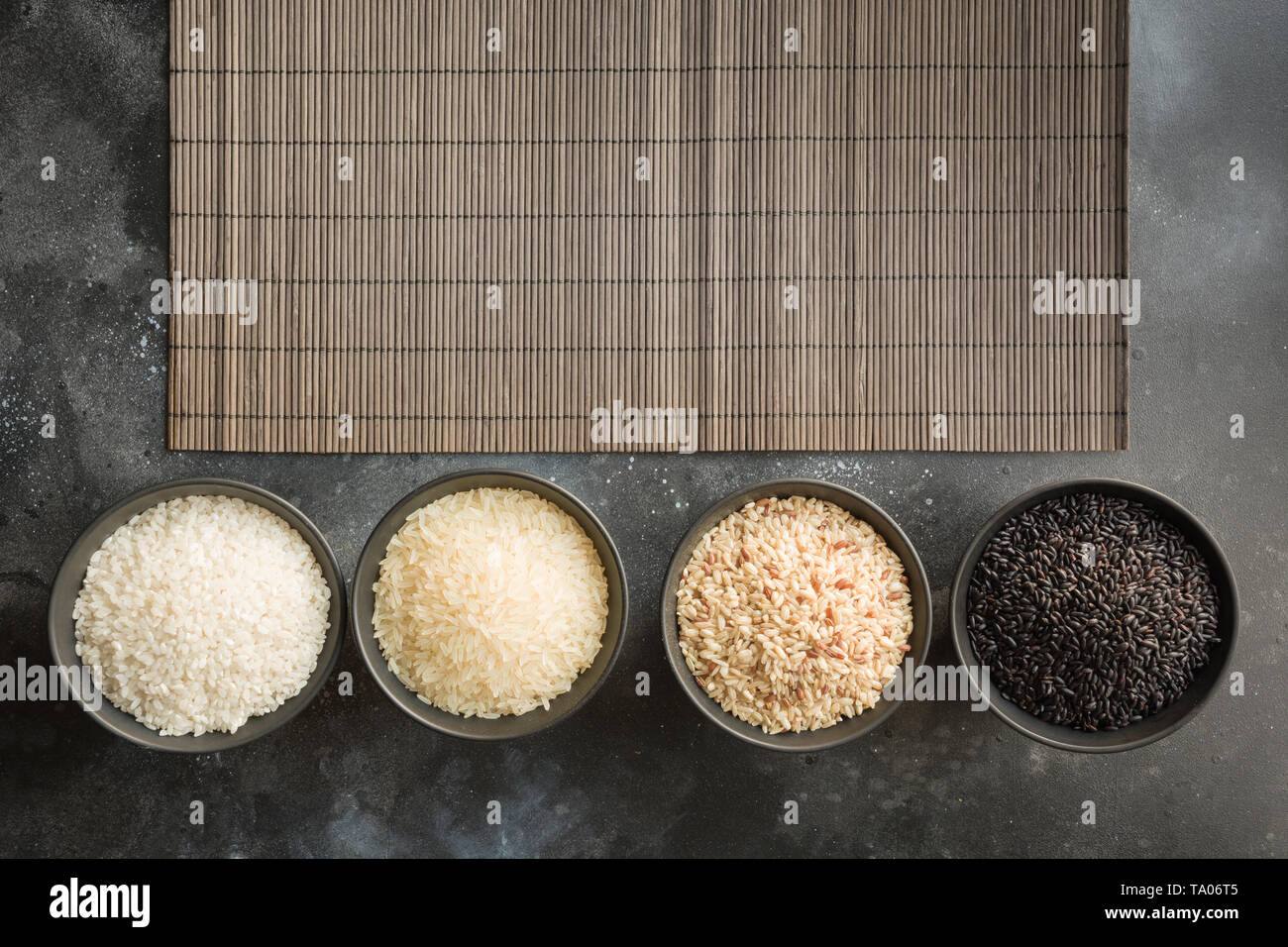 Different varieties of white, black , brown, steamed rice in bowls ...