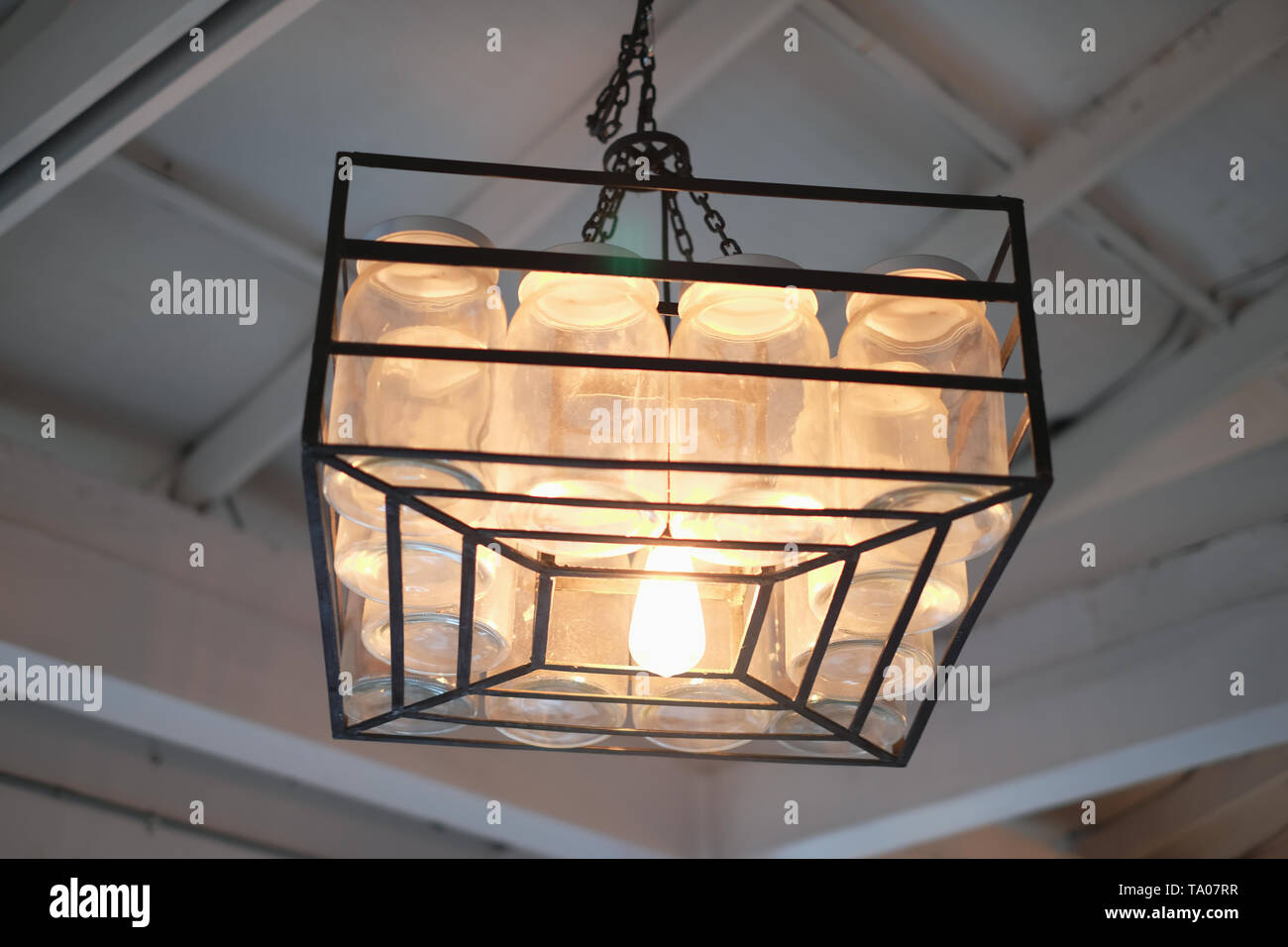 Hanging a dozen of bottles lamp on vintage ceiling Stock Photo