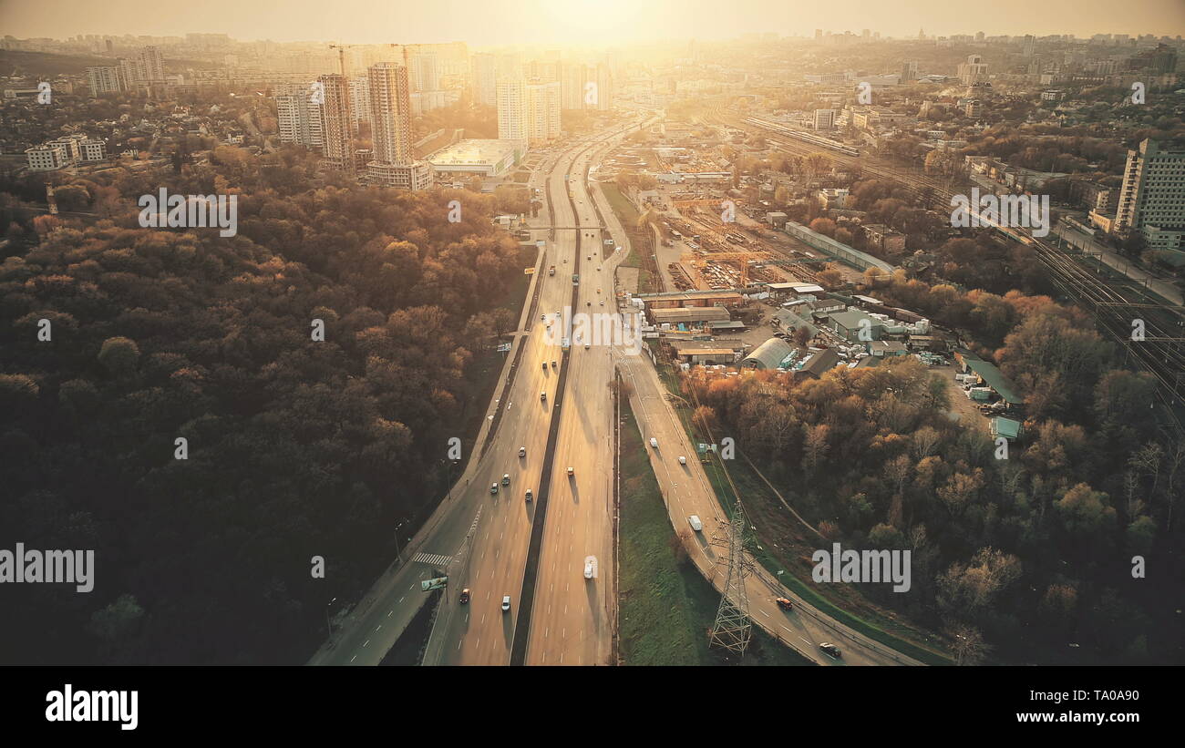 Urban Car Road Traffic Congestion Aerial View. City Street Motion Lane, Drive Navigation Overview. Busy Cityscape Speed Route with Forest Park Around. Travel Concept Drone Flight Shot Stock Photo