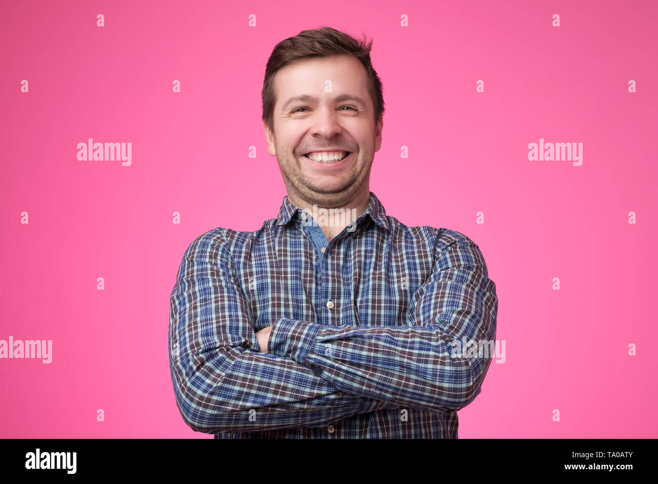 young man in shirt standing with arms crossed Stock Photo