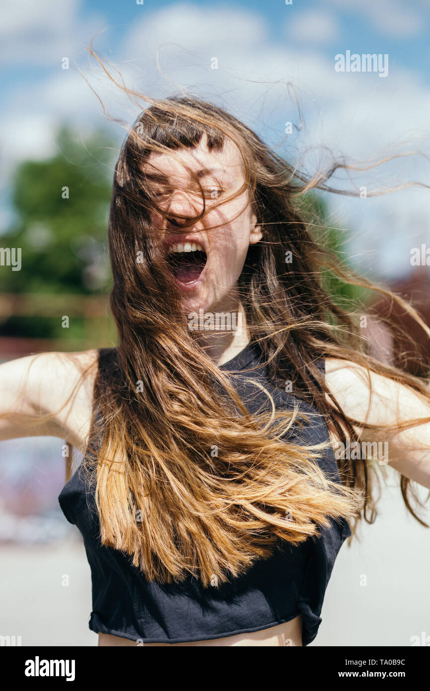 Young woman with long hair screaming Stock Photo