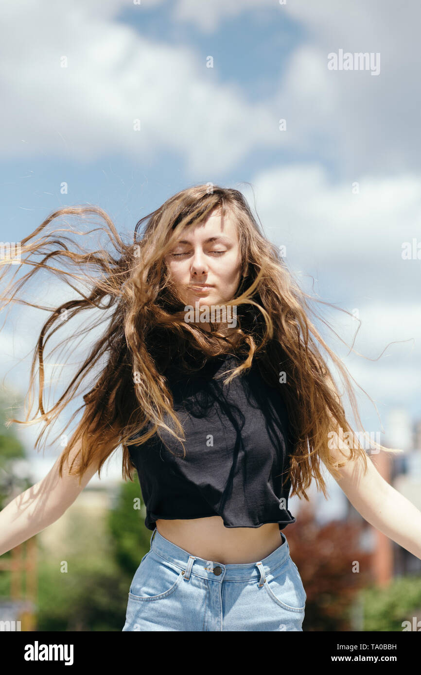 Young woman with long hair jumping Stock Photo