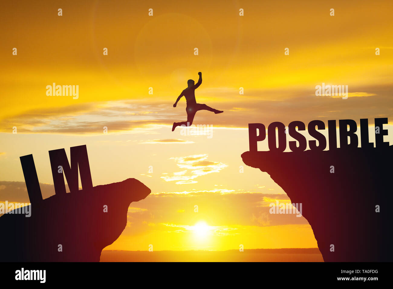 Man jumping over impossible or possible over cliff on sunset background Stock Photo
