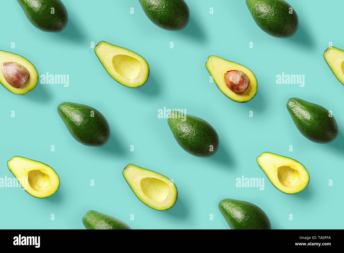 Avocado pattern on blue background. Pop art design, creative summer food concept. Green avocadoes, minimal flat lay style. Top view. Stock Photo