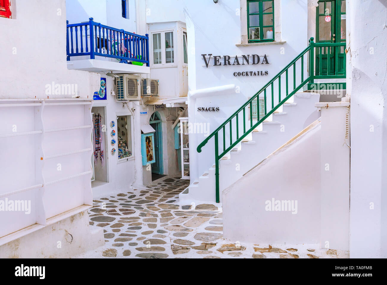 Mykonos, Greece - April 23, 2019: Famous island street view with white houses and souvenir gift shop in Cyclades Stock Photo