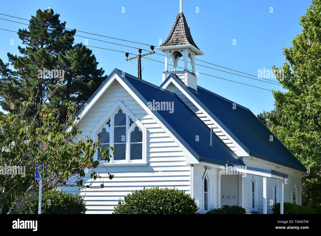 Wooden Anglican church of St Leonard in Matakana with bright white cladding and blue roof. Stock Photo