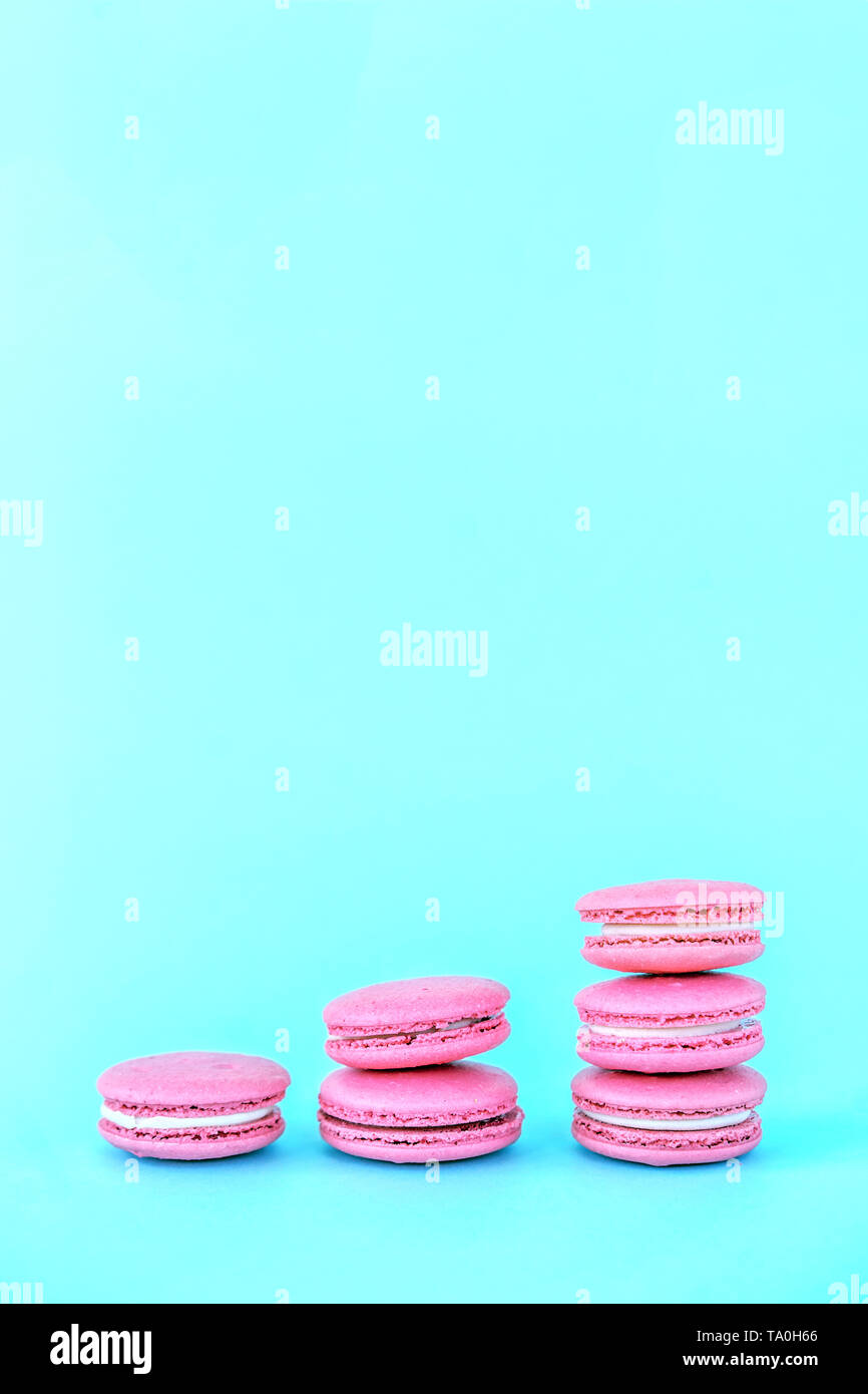 Pink macaroons on a blue background. Concepts of classification and growth Stock Photo