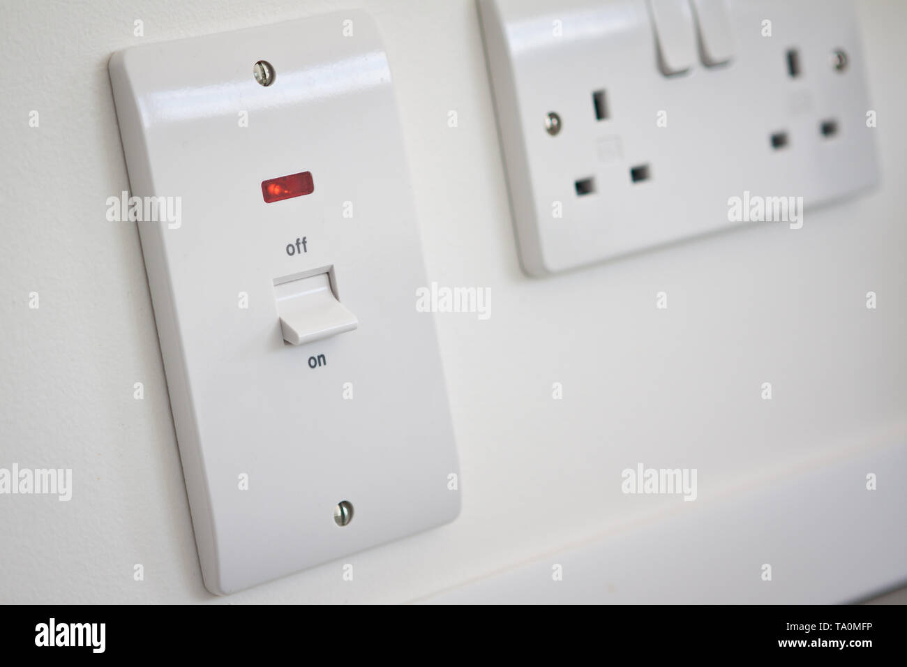 A power on off switch in the on position and socket. Stock Photo