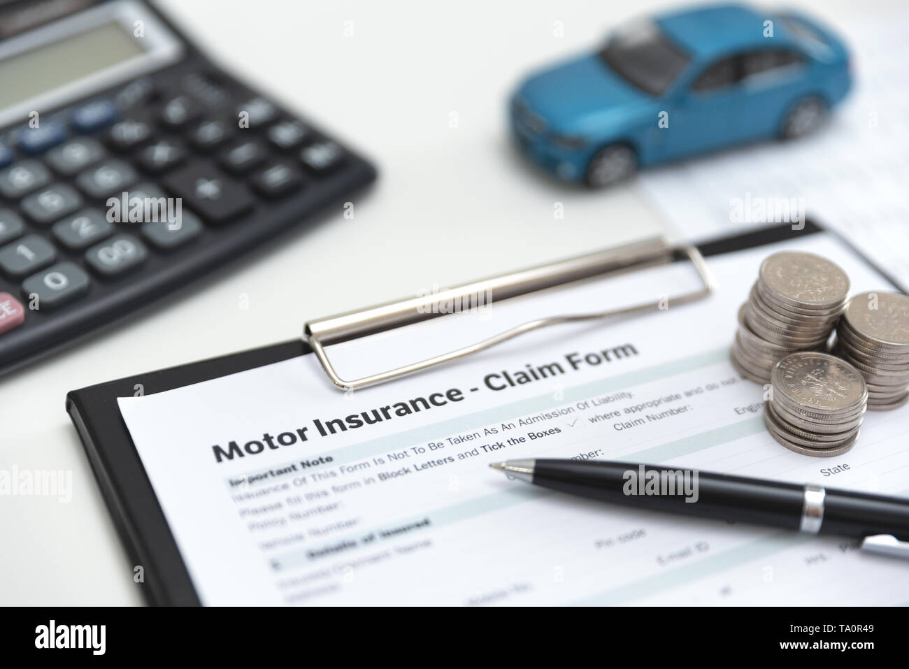 Motor or car insurance claim form with coin stack, calculator and car model. Stock Photo