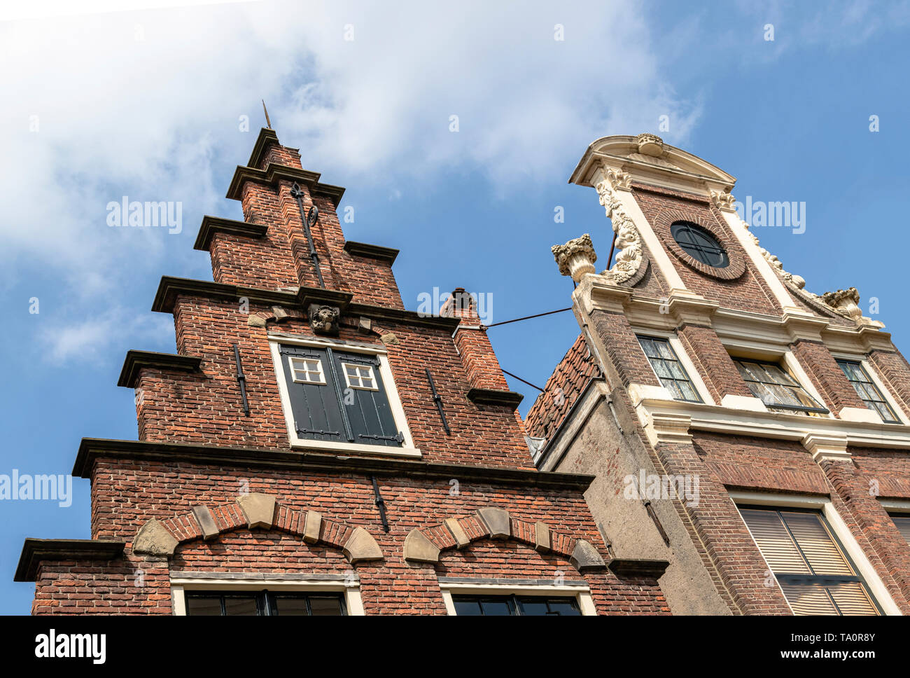 Low angle view of crow-step gable and clock gable architecture in Haarlem, North Holland, The Netherlands. Stock Photo