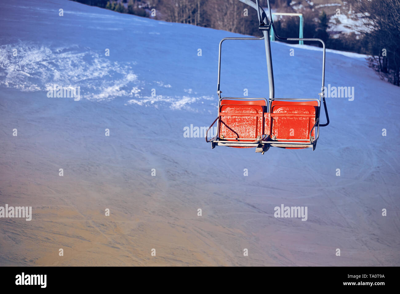 Ski lift with seats going over the mountain and paths from skies and