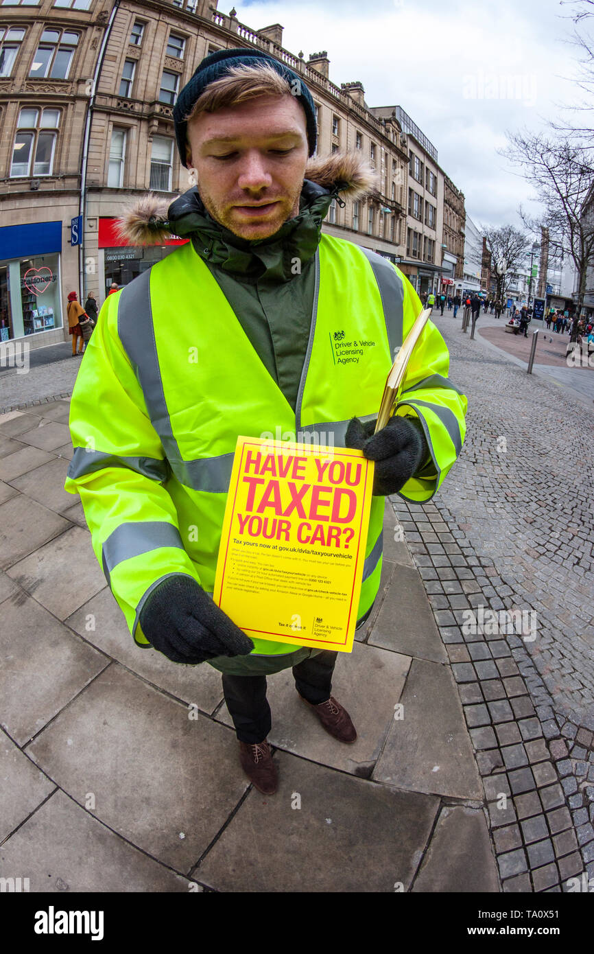 DVLA Representative holding 'Tax it or we'll clamp it' campaign leaflet Stock Photo