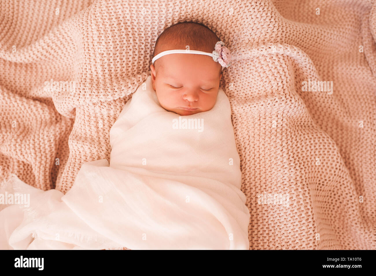 Sleeping swaddled baby girl lying in bed closeup. Healthy sleep