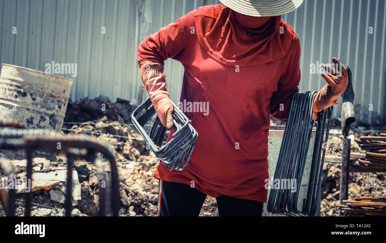 Worker hold blending round bar steel on construction site for civil