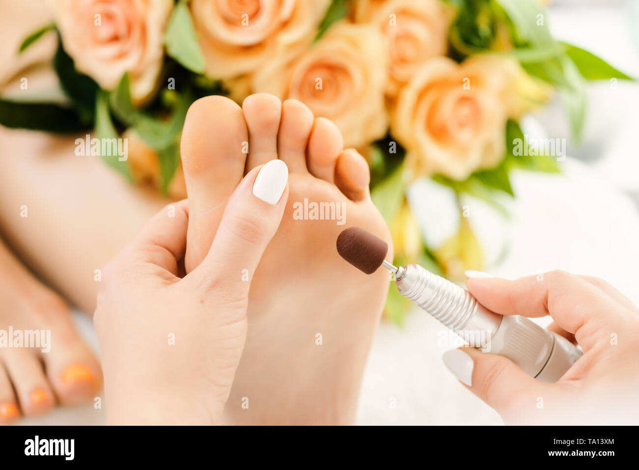 Podiatrist in podiatry session working of feet of client Stock Photo