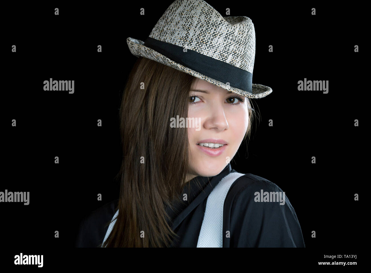 girl with braces and  man's hat on a black background Stock Photo