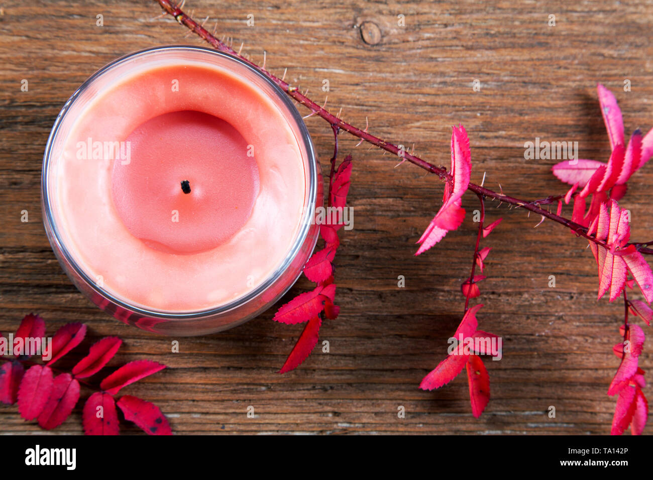 Still-life with a candle and dry red leaves Stock Photo
