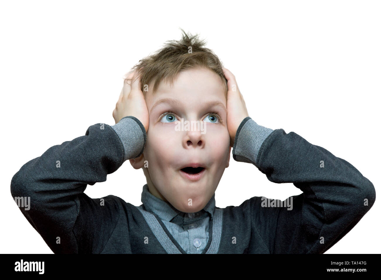 the boy with a surprised look clutched at his head. Isolated on white background Stock Photo