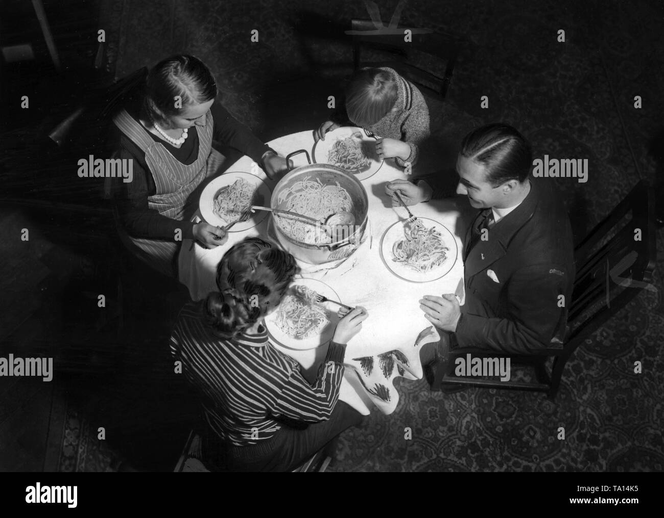 Symbolic picture of the Nazi-propaganda on the Eintopf Sonntag (Stew Sunday) program of the Winter Relief: Family when eating. (Undated photo) Stock Photo