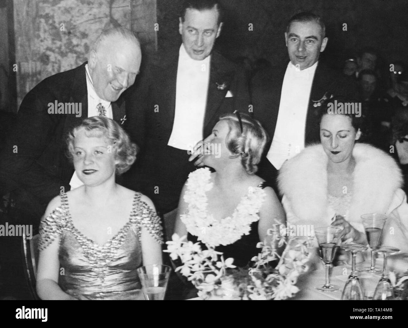 A box at the Berlin Film Ball. First row: The actresses Hilde Krueger, Maria Paudler and Dorothea Wied. In the second row: the Berlin police chief Magnus von Levetzow, the actor Karl Ludwig Diehl and the composer Clemens Schmalstich. Stock Photo