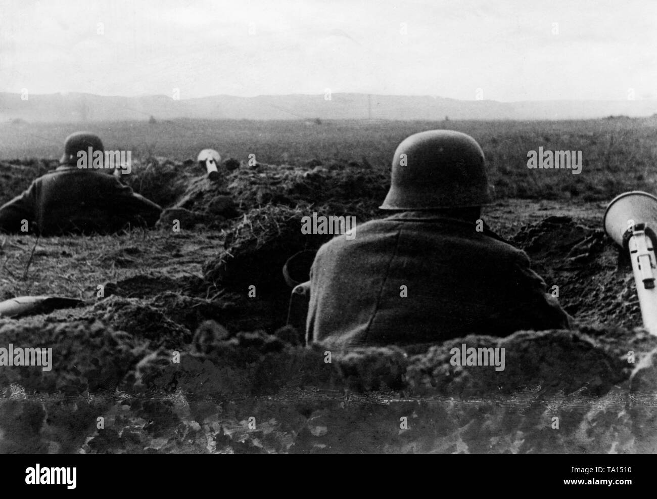 Soldiers of the Wehrmacht in their foxholes awaiting the onslaught of the Red Army in Berlin. Beside the soldiers there are anti-tank rocket launchers, often the only remaining weapon against the Russian tanks. Stock Photo