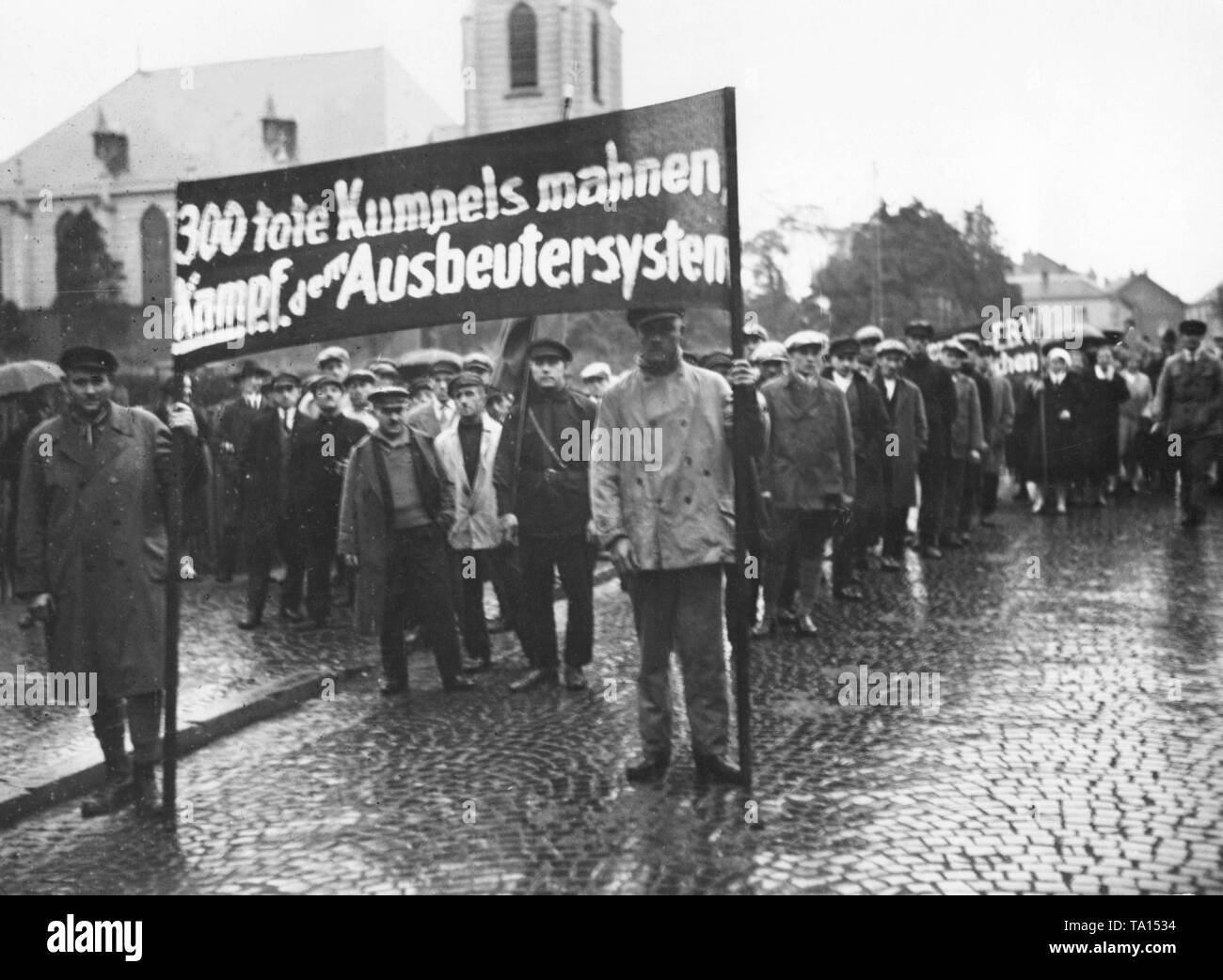 297 people died in the mining disaster Alsdorf in October 1930, subsequently supporters of the KPD (German Communist Party) march through the streets of the city. On the banner reads: '300 dead mates enjoin a fight against the exploiter system'. Stock Photo