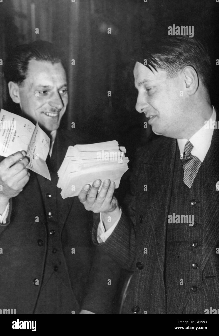 Two campaign workers hold the counted ballots in their hands. On the right the No votes and on the left the Yes votes. At the referendum was voted on the annexation of Austria to the German Reich. Stock Photo