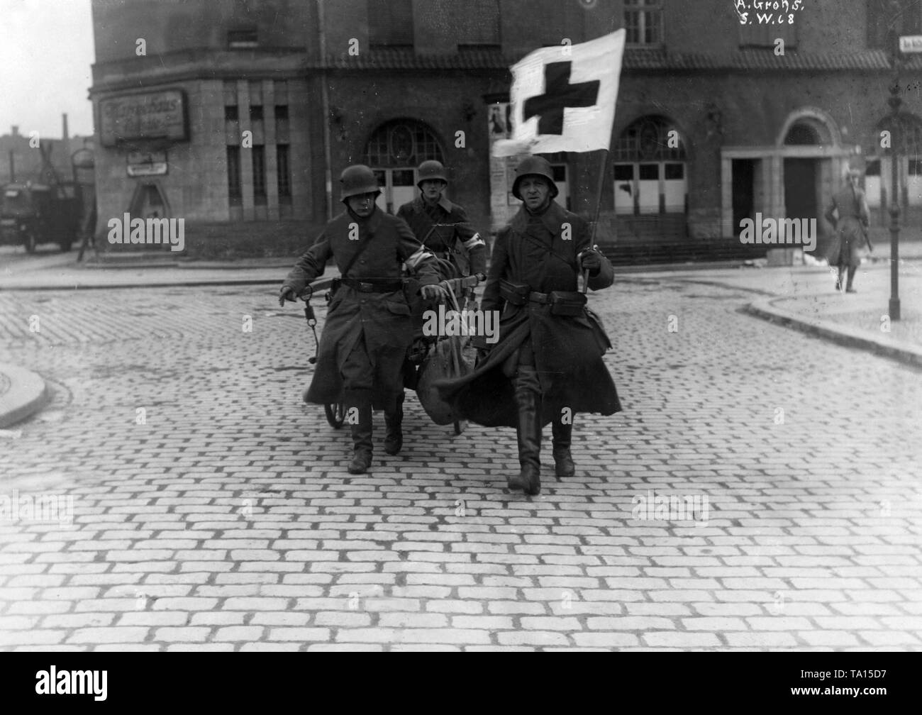 Paramedics of the government-loyal troops bring an injured person to safety. During the January uprising, there were armed conflicts in the Berlin Zeitungsviertel (newspaper quarter) between left-wing revolutionaries and government-loyal Freikorps units. Stock Photo