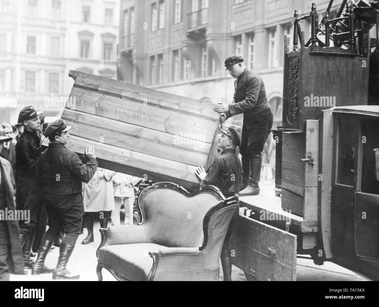 Money shortage and political pressure caused the NSDAP to give up offices again and again. Here pieces of furniture from the previous quarter of the Gau leadership of the Nazi Party in the Hedemannstrasse are forcibly cart away. Stock Photo