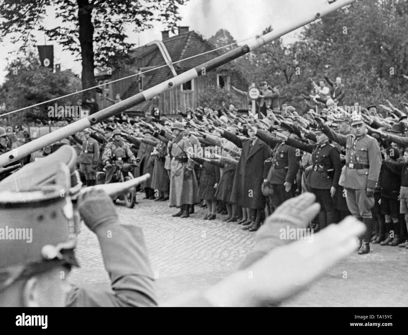 German troops cross the former German-Czechoslovak border at Ebersbach / Georgswalde (today Jirikov) on October 2, 1938. People salute them with the Nazi salute. Stock Photo