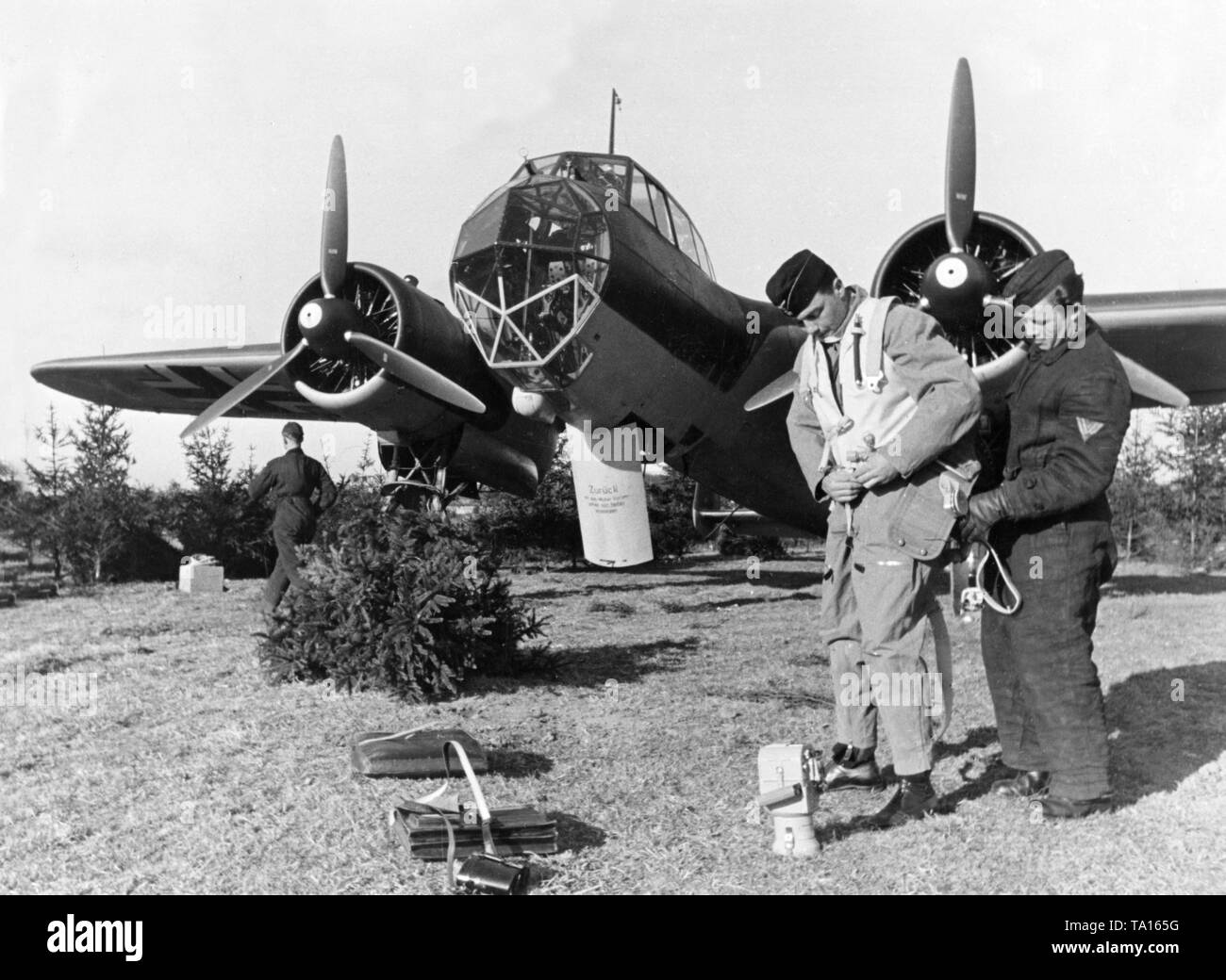 Dornier Do 17 Combat aircraft preparing for takeoff. A man of the ground staff helps a member of the crew with the flight suit. Stock Photo