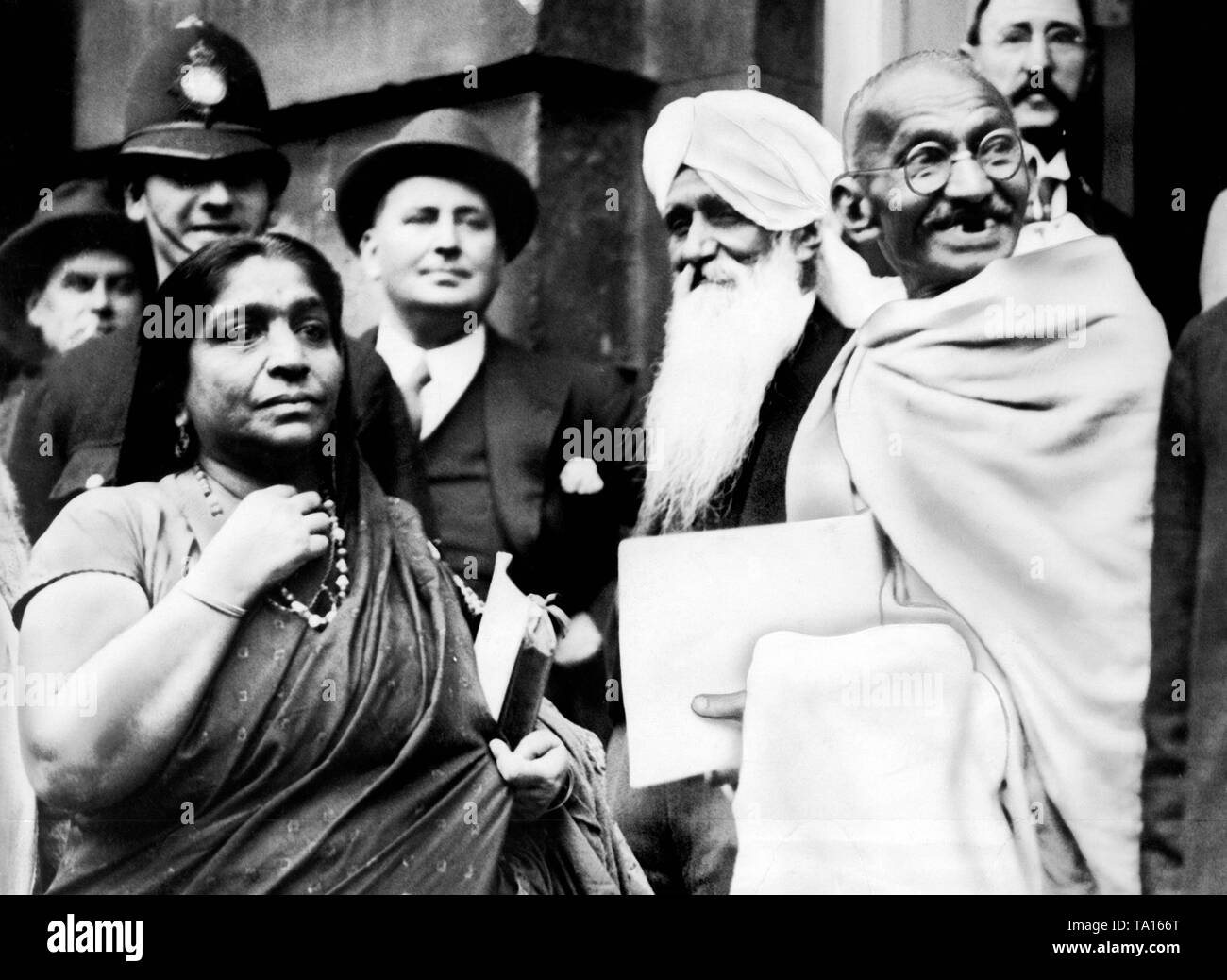 The Indian Nationalist leader Mahatma Gandhi leaves the St. James's Palace, along with the poet and politician Sarojini Naidu and Sir Pattani, following the Indian Round Table Conference. Stock Photo