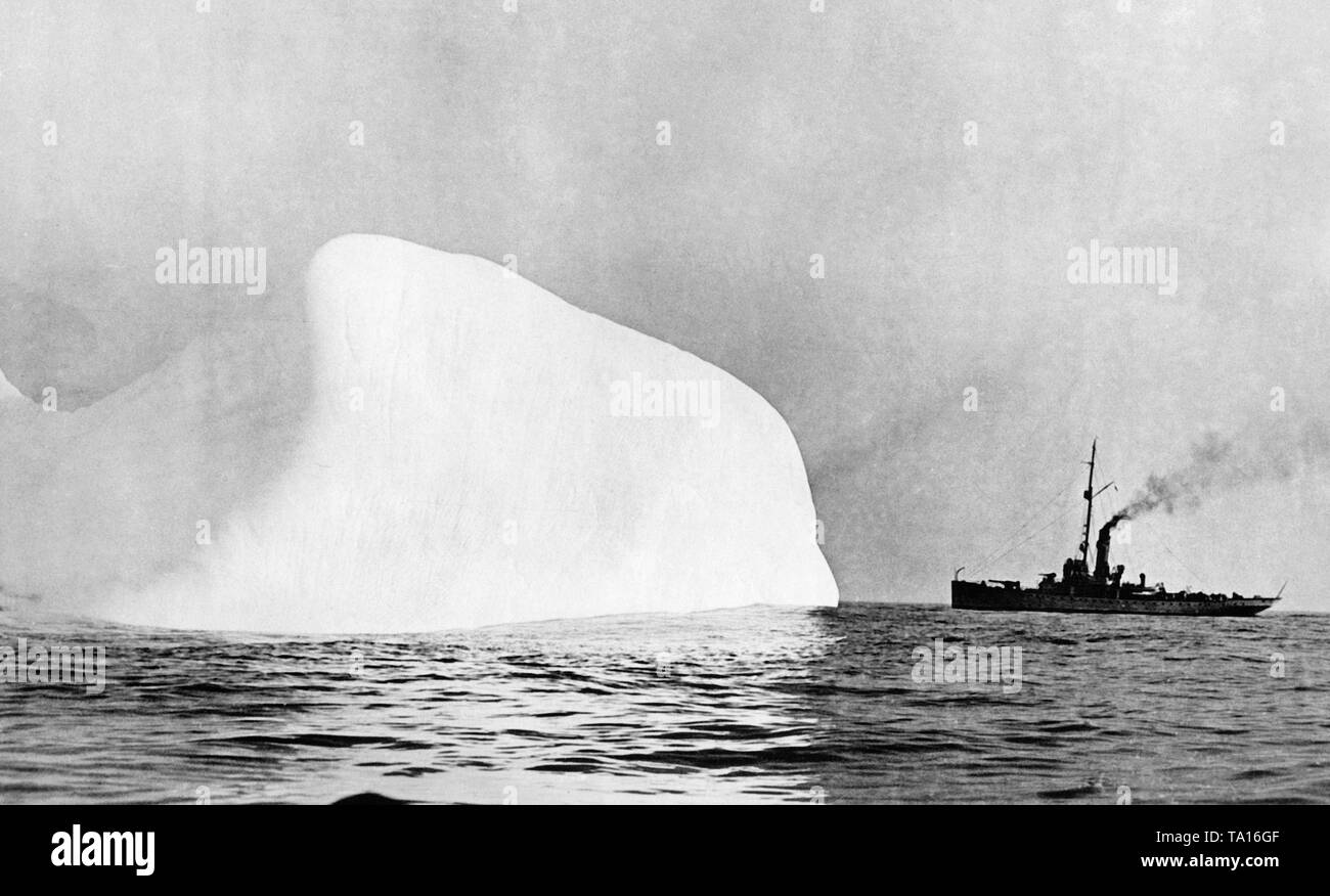 A US Coast Guard ship sails around an iceberg. The Ice Guard was established as a result of the sinking of the White Star ship Titanic. Stock Photo