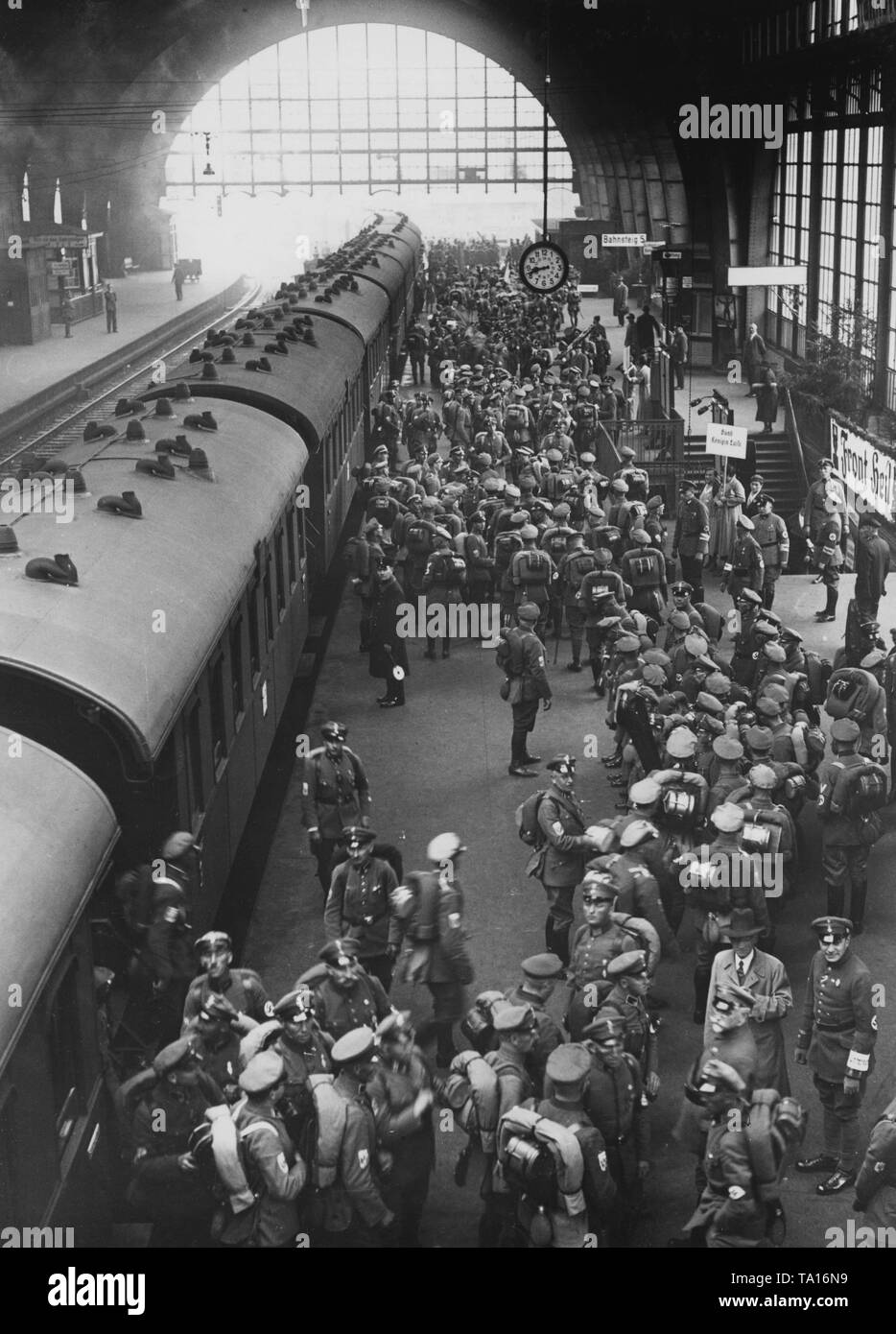 On the occasion of the Reich leadership meeting of the Stahlhelm, a special train with participants from the Ostmarkt and Brandenburg arrives at the Hannover Hauptbahnhof. On the right, a woman carries a shield for the 'Bund Koenigin Luise' (Women's Organization of the Stahlhelm). On the right, there is a banner with the inscription 'Front heil!' to be seen. Stock Photo
