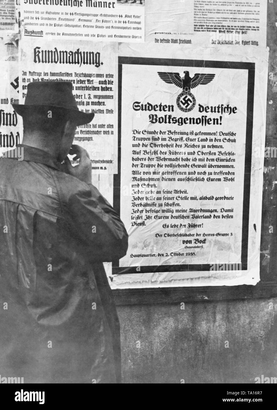 According to the Munich Agreement in October 1938, Czechoslovakia had to cede the Sudeten German territories to the German Reich. A man reads an announcement by Adolf Hitler to Sudeten German people. Stock Photo