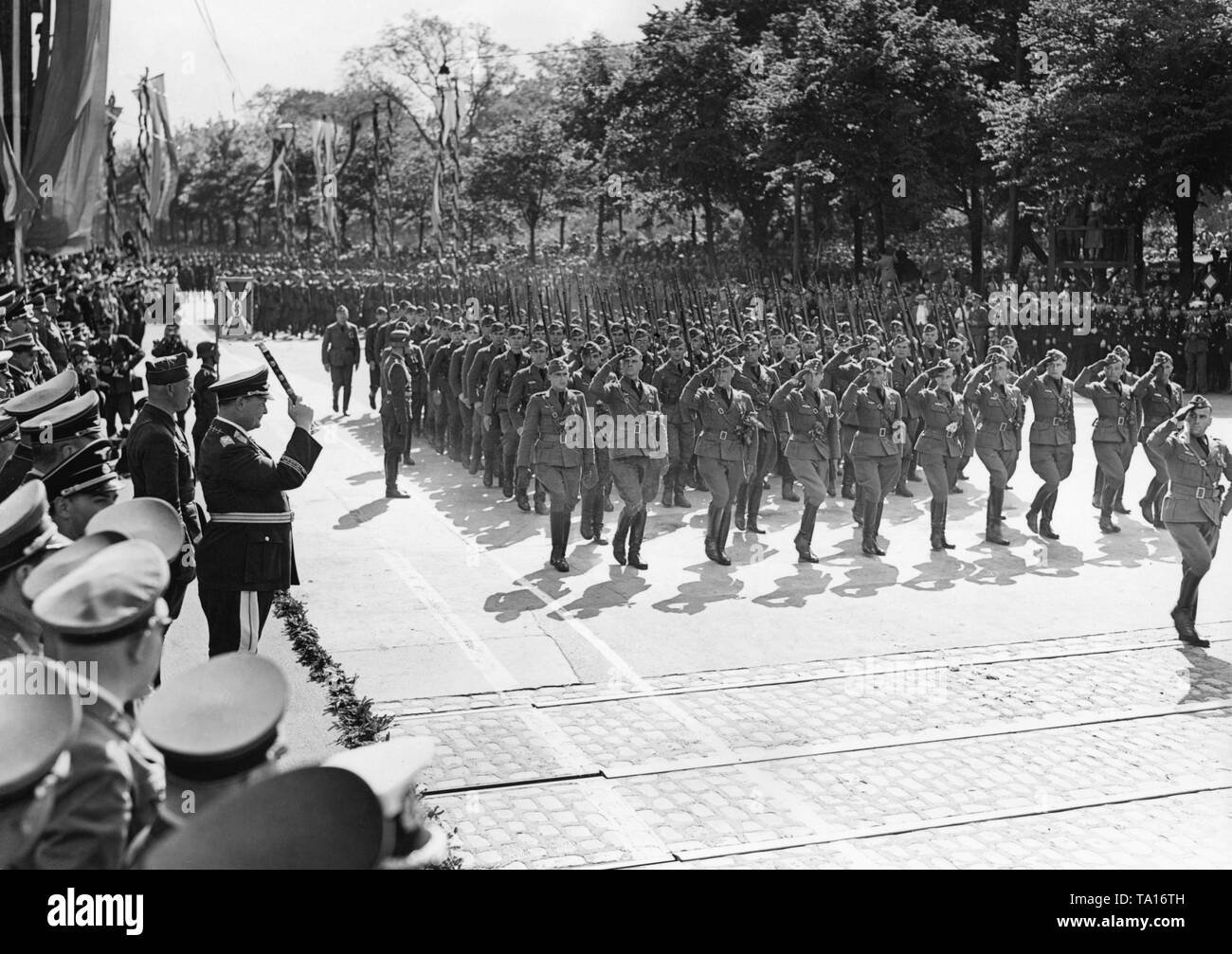 Photo of a unit of the Condor Legion (at the very front, saluting pilot officers) marching in front of the chief commander of the Luftwaffe, Field Marshal General Hermann Goering (on the left with general's baton) at Karl Muck Platz (now Johannes Brahms Platz) in Neustadt, Hamburg, on May 30, 1939. Stock Photo