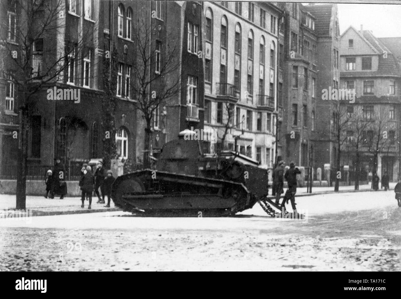 A French tank of the occupation forces shields soldiers in the Lindemannstrasse of a German city in the Ruhr area. Stock Photo