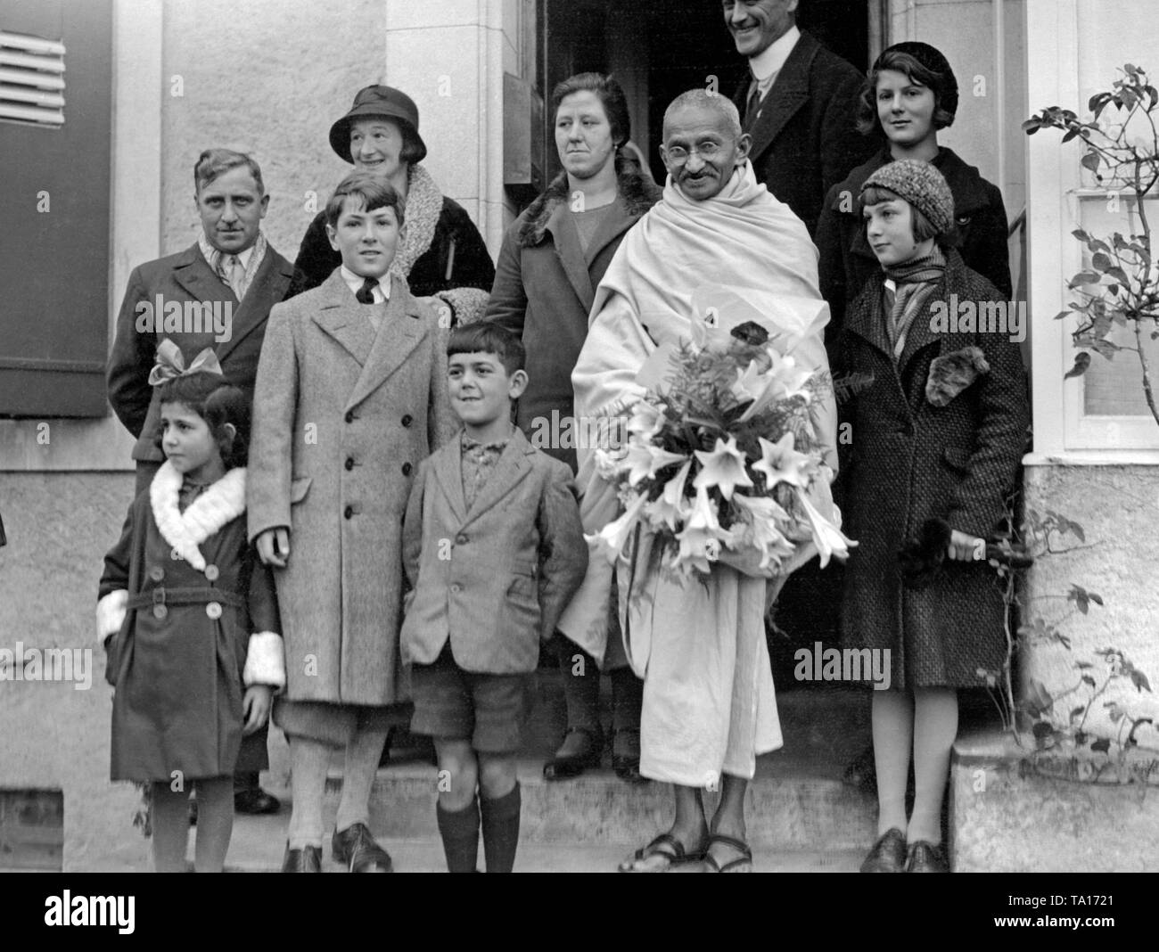 Mahatma Gandhi during his stay in Villeneuve in Switzerland. The flowers  are a gift of the children Stock Photo - Alamy