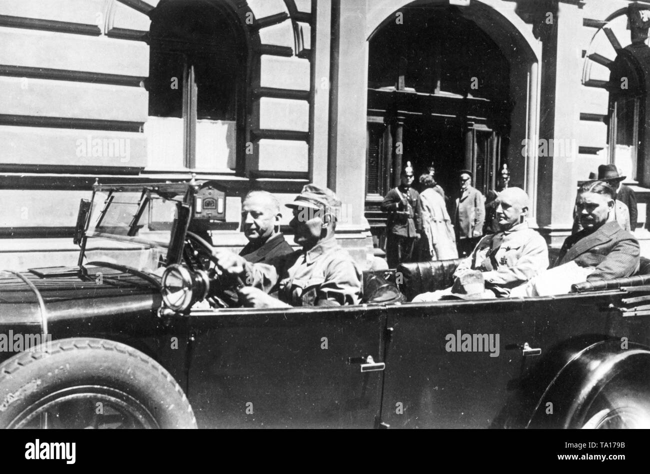 Departure of the Nazi leaders from the Bavarian Landtag building, which is secured by the police with carabiners. The members of the NSDAP were led out from the government building on command of the President of the Landtag, as they had previously refused to take off their party uniforms. In the car at the rear on the left, the future Gauleiter of Frankonia, Julius Streicher. Next to the driver, the later Gauleiter of Munich in Upper Bavaria, Adolf Wagner. Stock Photo