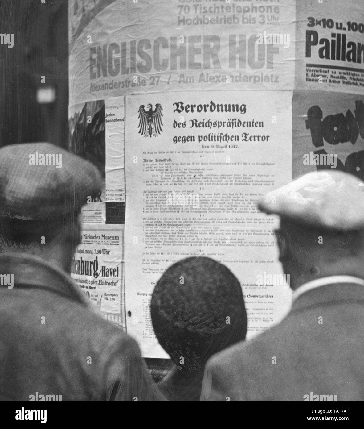 On August 9, Reich Chancellor von Papen introduced the death penalty for political murder and use of explosives to end the civil war-like street battles between the KPD and the NSDAP. Here, citizens are looking at the decree against political terror on a poster on an advertising column. Stock Photo