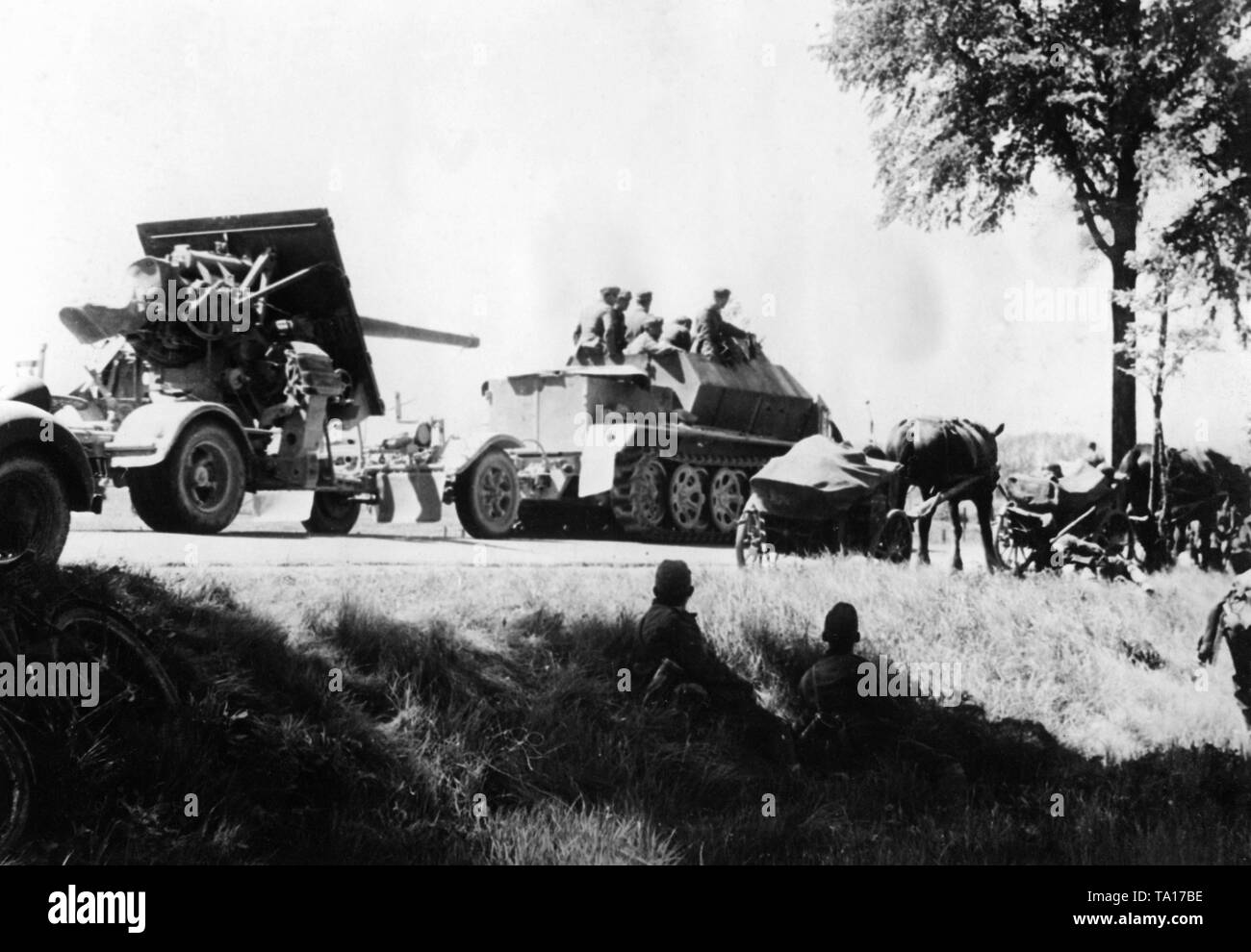 An armored anti-aircraft unit with 8.8 cm FlaK 18/36/37 on trailers during the advance in France. The vehicle is a 'Gepanzerten Zugkraftwagen 8t', a version of the Sd.Kfz. 7. This type of vehicle combination was often used to combat bunkers. Stock Photo