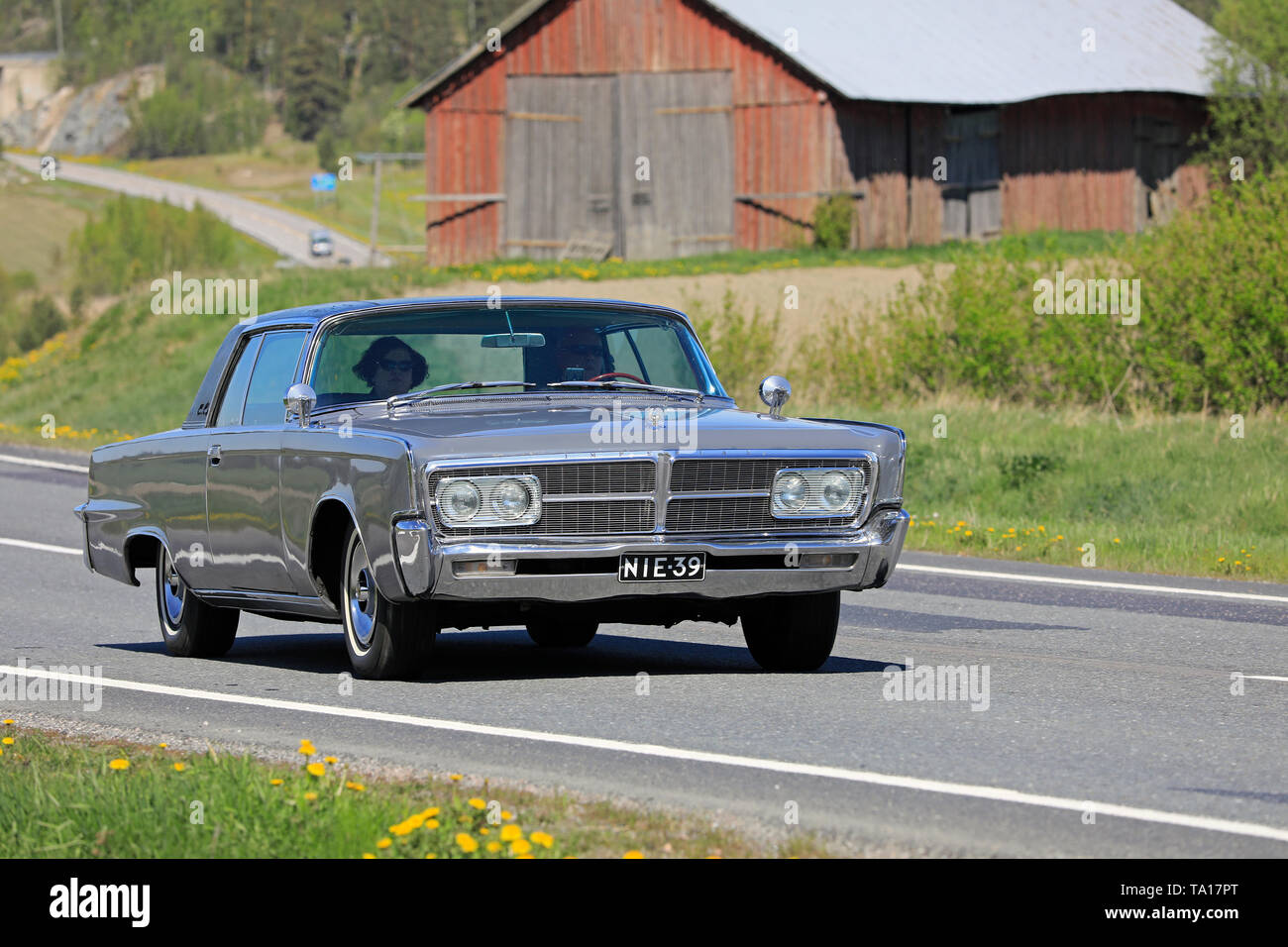 Salo, Finland. May 18, 2019. Classic grey Imperial car, mid 1960s, on road along rural highway to participate in Salon Maisema Cruising 2019. Stock Photo