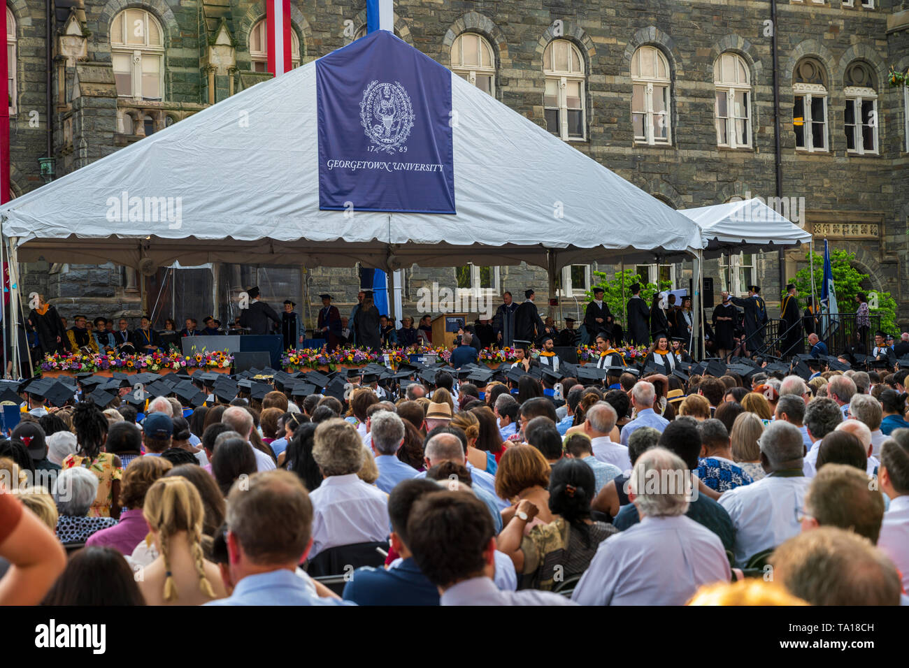 Washington, DC , USA -- May 19, 2019. A large audience of parents, friends and relatives watches as new graduates of Georgetown University file in at Stock Photo