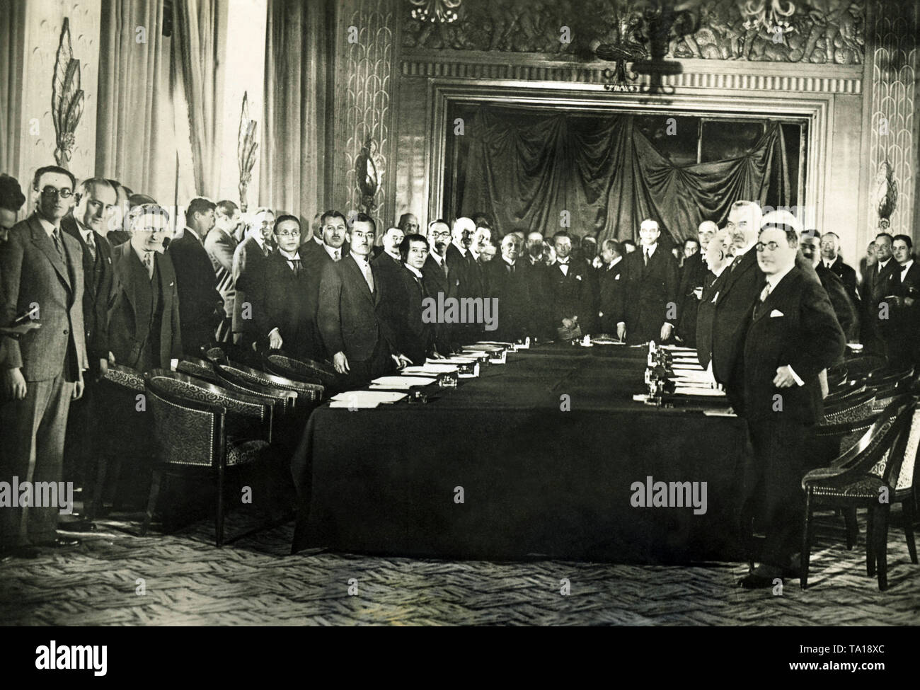 The representatives of the belligerent powers met in the Hotel George V to discuss the reparation payments of Germany. The German representatives pointed out in vain the economic weakness of Germany. Here is the opening of the conference. Standing at the front of the table: in the center Owen Young, at the left corner Moreau and at right Morgan. On the right, 3rd from the front German expert, Voegler. Stock Photo